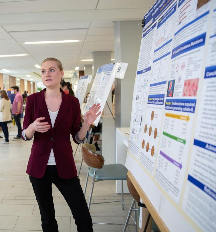 student giving poster presentation