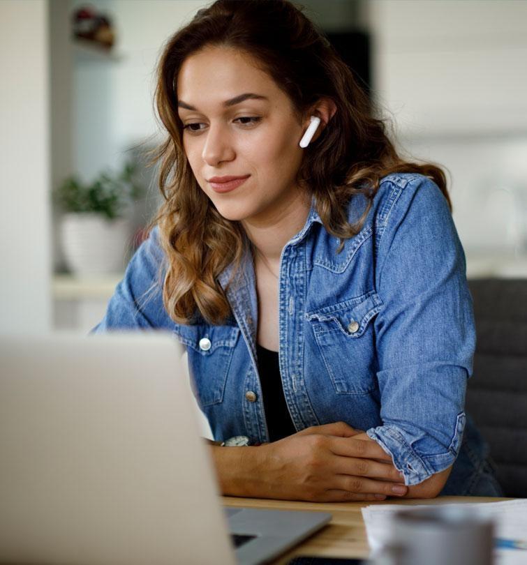 student at laptop with earbuds