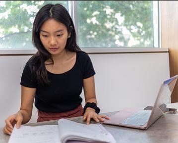 woman looking at notebook at desk