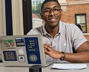 Student sitting at laptop smiling