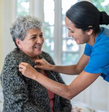 nurse providing at home care to elderly patient