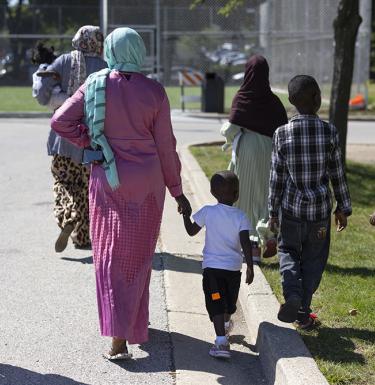 children and adults attend a back to school event. Photo credit: AP News