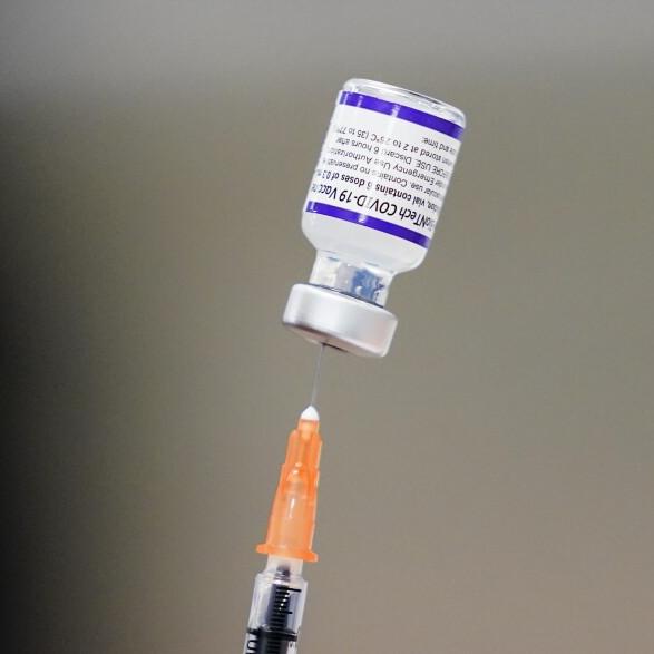 A syringe is prepared with the Pfizer COVID-19 vaccine at a vaccination clinic.