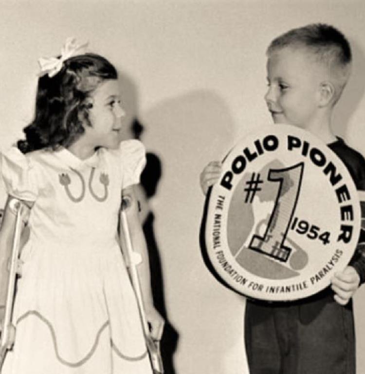 young boy and girl with Polio Pioneer sign and girl on crutches